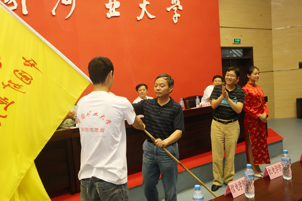 校庆办主任,原副校长周建国向志愿者授旗